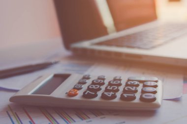 Hesap makinesi, dizüstü bilgisayar, kalem ve resepsiyon beyaz evde finansal verilerin analizi 