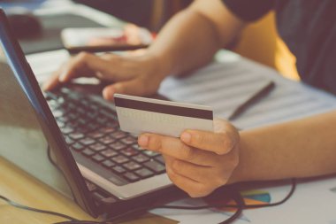 kredi kartı tutan ve online ödeme online, online alışveriş yapma dizüstü kullanarak kadın el
