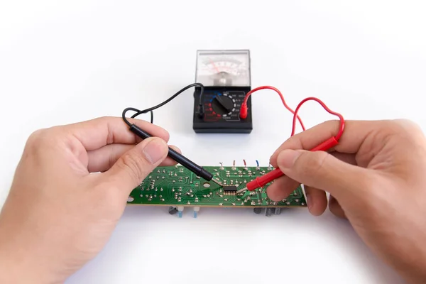 Technician hand with multimeter probes repairing circuit board