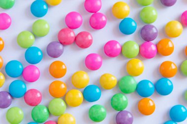 Renkli tatlı şeker çikolata kaplı beyaz kağıt üzerine yığını. renkli koleksiyonu