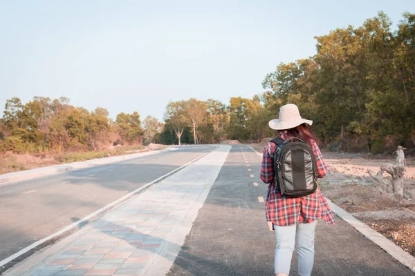 旅行の概念 アスファルト道路の田舎を歩いてバックパックで旅の女性 — ストック写真