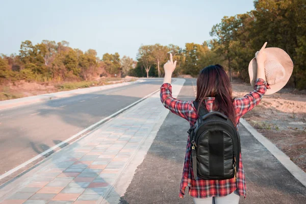 旅行の概念 アスファルト道路の田舎を歩いてバックパックで旅の女性 — ストック写真