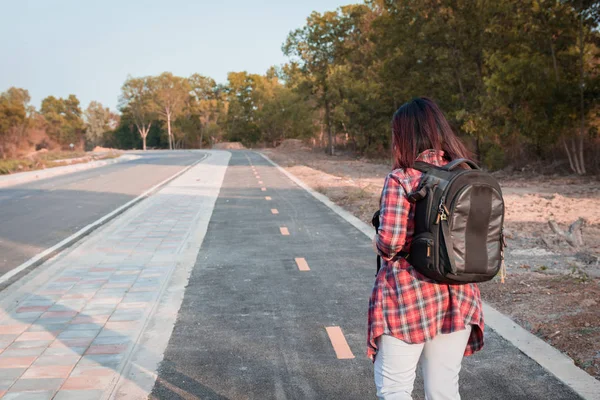 旅行の概念 アスファルト道路の田舎を歩いてバックパックで旅の女性 — ストック写真