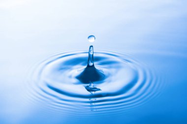 Suya düşen su damlası dalgalar yapar. Su sıçraması veya su damlası arka plan. 