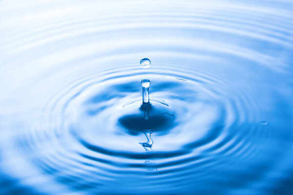 Water drop falling into water make waves. Water splash or water drop background. 