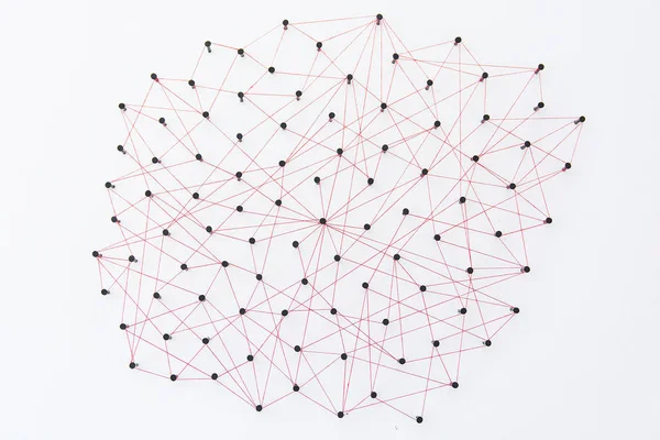Linking entities, social media, Communications Network, The connection between the two networks. Network simulation on white paper linked together created by black nail and red thread