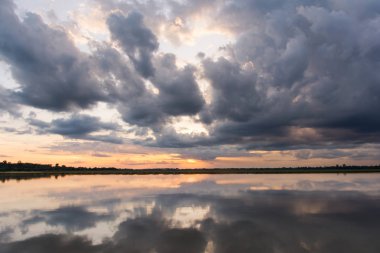 Göl günbatımı. Fırtına bulutları üzerinden yukarıda gök gürültüsü fırtına öncesi arkasında güzel gün batımı göl manzara arka plan. Gün batımında bulut ile dramatik gökyüzü.