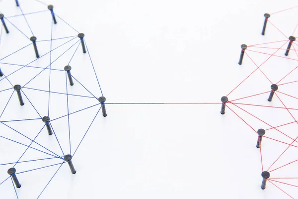 Connecting networks concept - two network connected with yarn red and blue on white paper. Simulator connection social media, internet, people communication