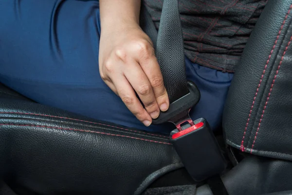 Car seat belt. woman fastens the seat belt on car Safe driving. Safety belt in hand.