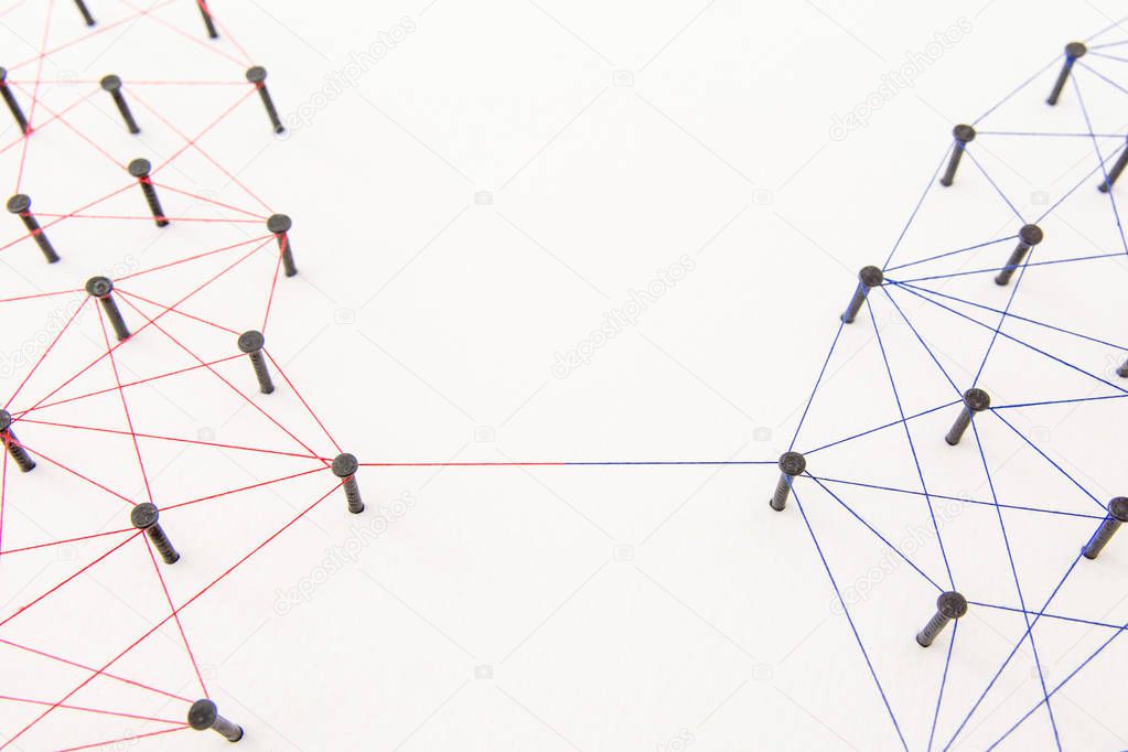 Connecting networks concept - two network connected with yarn red and blue on white paper. Simulator connection social media, internet, people communication