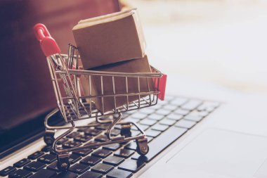 Online kavramı alışveriş - online web üzerinde hizmet alışveriş. evlere servis sunmaktadır. bir dizüstü bilgisayar klavye logosuna parsel veya kağıt karton bir alışveriş sepeti