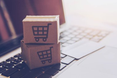 Online kavramı alışveriş - online web üzerinde hizmet alışveriş. ödeme kredi kartı ve teklifler eve teslim. bir dizüstü keyboar logosuna parsel veya kağıt karton bir alışveriş sepeti
