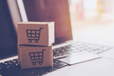 Online kavramı alışveriş - online web üzerinde hizmet alışveriş. ödeme kredi kartı ve teklifler eve teslim. bir dizüstü keyboar logosuna parsel veya kağıt karton bir alışveriş sepeti