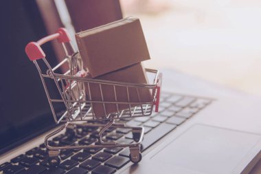 Online kavramı alışveriş - online web üzerinde hizmet alışveriş. evlere servis sunmaktadır. bir dizüstü bilgisayar klavye logosuna parsel veya kağıt karton bir alışveriş sepeti