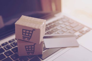 Online kavramı alışveriş - online web üzerinde hizmet alışveriş. ödeme kredi kartı ve teklifler eve teslim. bir dizüstü keyboar logosuna parsel veya kağıt karton bir alışveriş sepeti