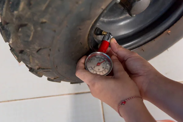 Tire pressure gauge : Hand holding pressure gauge checking air pressure for car tire. Safe driving.