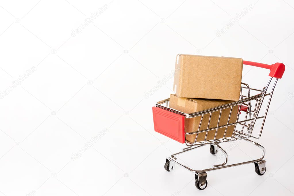 Shopping concept : Cartons or Paper boxes in red shopping cart on white background. online shopping consumers can shop from home and delivery service. with copy space