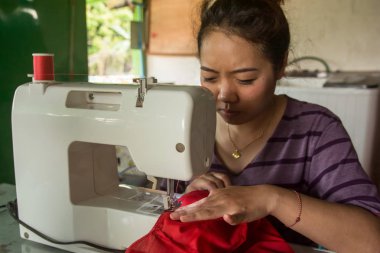 Yapım giysiler bir dikiş makinesi üzerinde çalışan kadın terzi. 