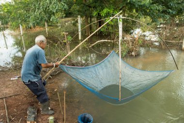 Nakhon Phanom, Tayland - 6 Eylül 2018: yaşlı adam rive üzerinde gurur ile balık yakalamak