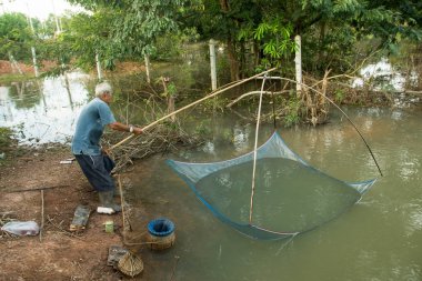 Nakhon Phanom, Tayland - 6 Eylül 2018: yaşlı adam rive üzerinde gurur ile balık yakalamak