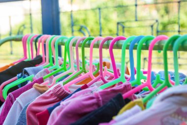 Bir raf üzerinde renkli elbise askısı