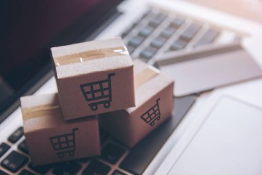 Online kavramı alışveriş - online web üzerinde hizmet alışveriş. ödeme kredi kartı ve teklifler eve teslim. bir dizüstü keyboar logosuna parsel veya kağıt karton bir alışveriş sepeti
