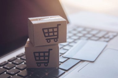 Online kavramı alışveriş - online web üzerinde hizmet alışveriş. ödeme kredi kartı ve teklifler eve teslim. bir dizüstü keyboar logosuna parsel veya kağıt karton bir alışveriş sepeti