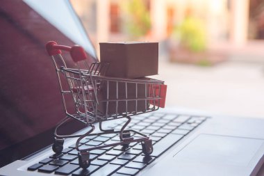 Online kavramı alışveriş - online web üzerinde hizmet alışveriş. ödeme kredi kartı ve teklifler eve teslim. parsel veya kağıt karton ile bir dizüstü bilgisayar keyboar üzerinde bir alışveriş sepeti