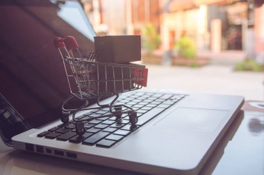 Online kavramı alışveriş - online web üzerinde hizmet alışveriş. ödeme kredi kartı ve teklifler eve teslim. parsel veya kağıt karton ile bir dizüstü bilgisayar keyboar üzerinde bir alışveriş sepeti