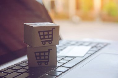 Online kavramı alışveriş - online web üzerinde hizmet alışveriş. ödeme kredi kartı ve teklifler eve teslim. bir dizüstü keyboar logosuna parsel veya kağıt karton bir alışveriş sepeti