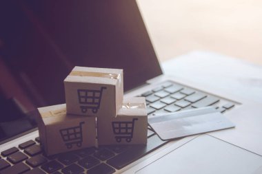 Online kavramı alışveriş - online web üzerinde hizmet alışveriş. ödeme kredi kartı ve teklifler eve teslim. bir dizüstü keyboar logosuna parsel veya kağıt karton bir alışveriş sepeti