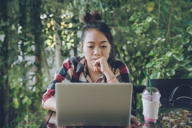 Yalnız bir dizüstü bilgisayarda çalışma kafede oturan genç Asya kadın