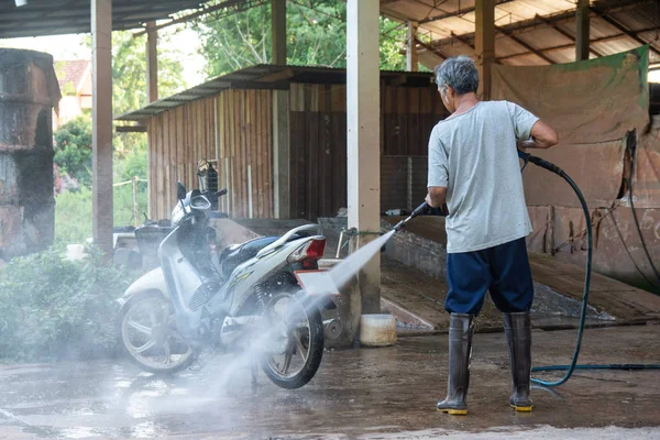 Old man wash your motorcycle with High Pressure Washer at car wa — Stock Photo, Image