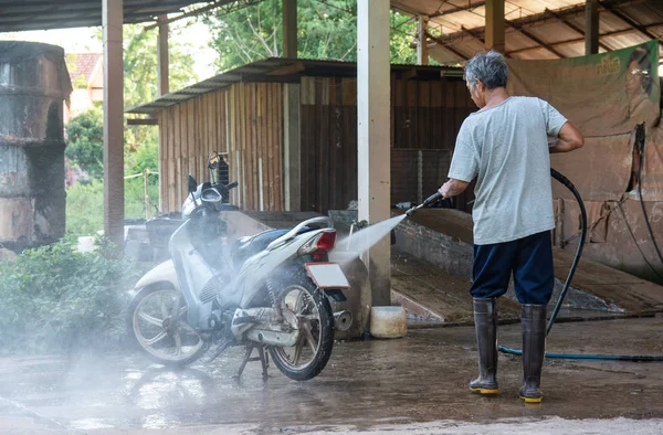 Old man wash your motorcycle with High Pressure Washer at car wa — Stock Photo, Image