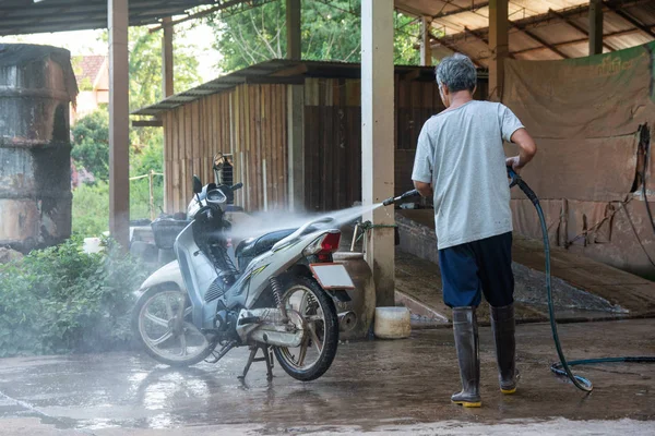 Old man wash your motorcycle with High Pressure Washer at car wa — Stock Photo, Image