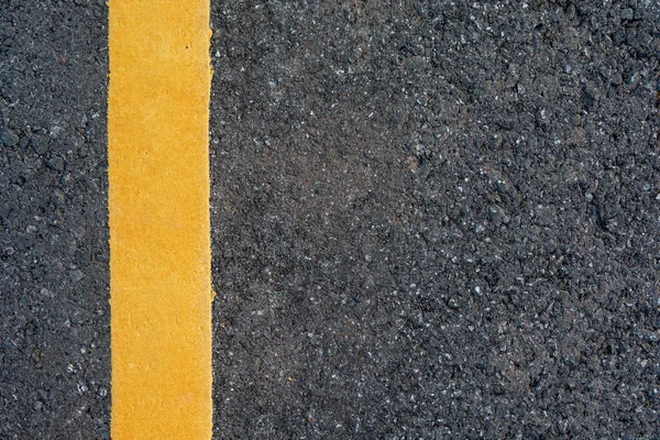 Yellow line on black asphalt road background with copy space — Stock Photo, Image