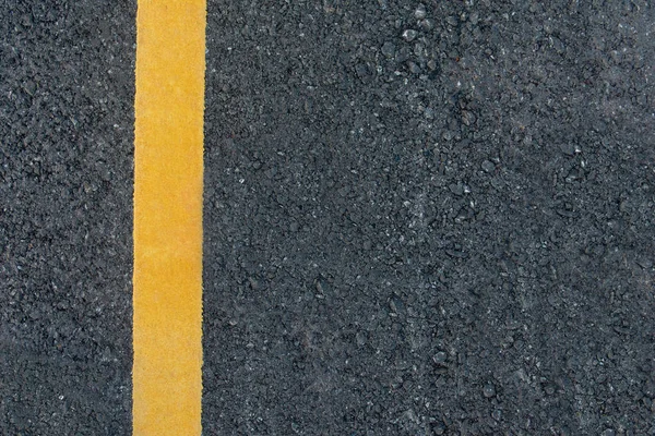 Yellow line on black asphalt road background with copy space — Stock Photo, Image