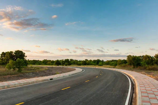 Curva de camino de asfalto vacía y cielo azul limpio en el día de verano backgr — Foto de Stock
