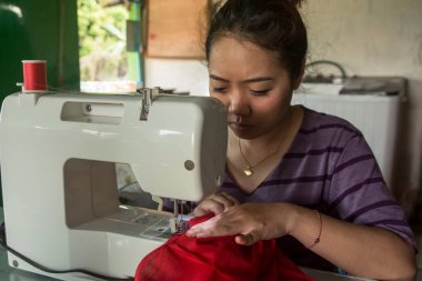 Yapım giysiler bir dikiş makinesi üzerinde çalışan kadın terzi. 