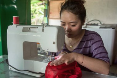 Yapım giysiler bir dikiş makinesi üzerinde çalışan kadın terzi. 