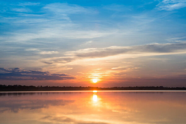 Sunset in the lake. beautiful sunset behind the clouds above the