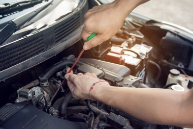 Garajda tornavida ile çalışan araba tamircisi. Tamir Servisi.