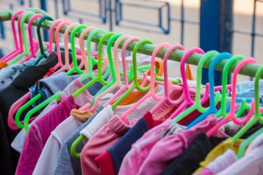 Bir raf üzerinde renkli elbise askısı