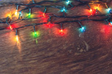 Koyu ahşap arka planda renkli noel ışıkları. Düz yatıyordu,