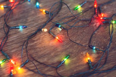 Koyu ahşap arka planda renkli noel ışıkları. Düz yatıyordu,