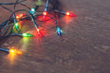 Koyu ahşap arka planda renkli noel ışıkları. Düz yatıyordu,