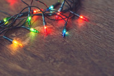Koyu ahşap arka planda renkli noel ışıkları. Düz yatıyordu,