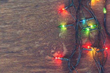 Koyu ahşap arka planda renkli noel ışıkları. Düz yatıyordu,