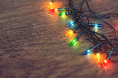 Koyu ahşap arka planda renkli noel ışıkları. Düz yatıyordu,