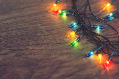 Koyu ahşap arka planda renkli noel ışıkları. Düz yatıyordu,